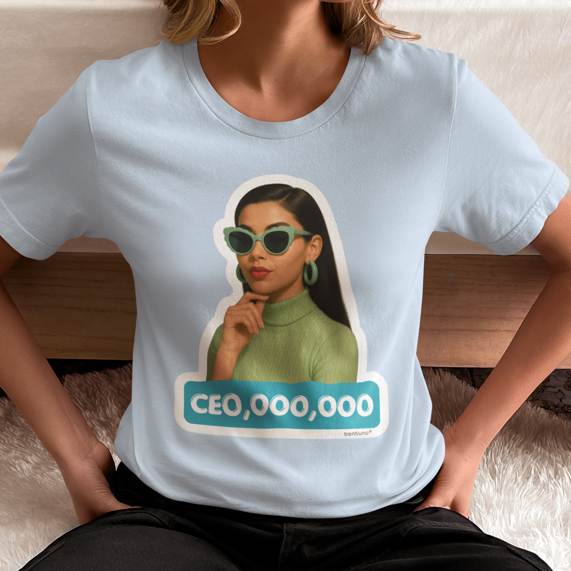 Person wearing a light blue t-shirt with a graphic of a woman and 'CEO,000,000' text.